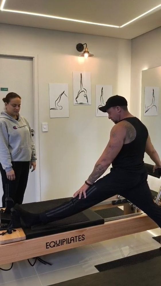 Aluna em exercício no Reformer com acompanhamento de perto da instrutora